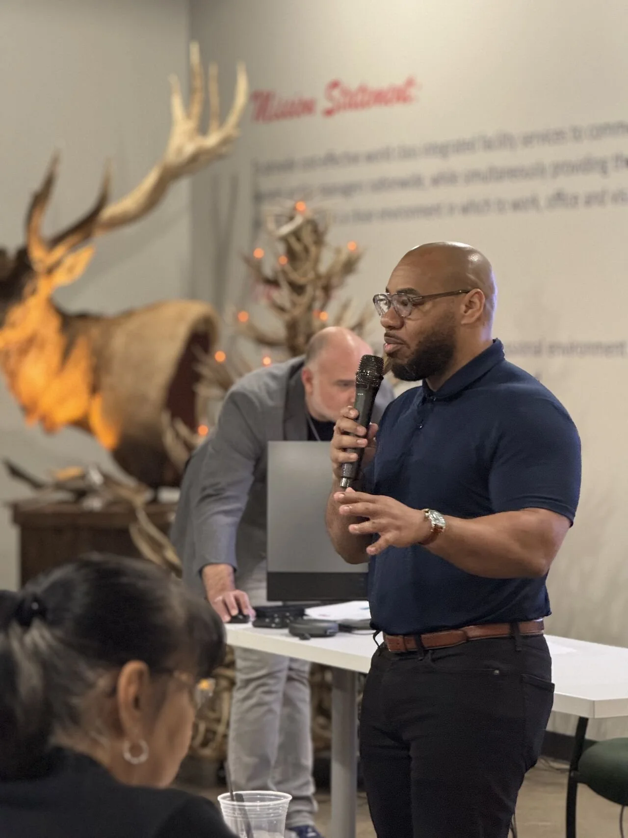 DeMarcus Strange speaking into a microphone in an intimate event setting