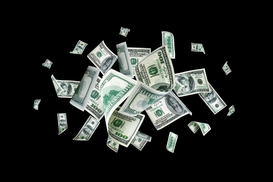 U.S. currency suspended against a black background